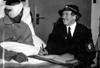 A Red Cross worker writes a letter for a wounded soldier in hospital 1944 � Catalogue reference: INF 2/43