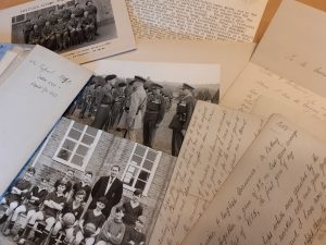 Letters and photos from from the Foster's Grammar School collection laid out on a table