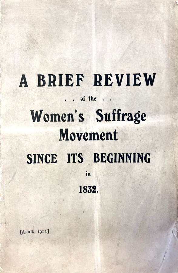 A worn, off-white printed page with visible creases and slight discoloration, featuring bold black text that reads: 'A Brief Review of the Women’s Suffrage Movement Since Its Beginning in 1832.' The page appears aged, with faint marks throughout.
