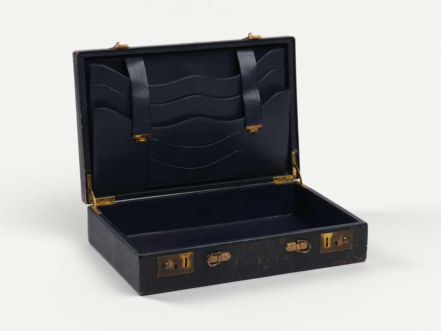 An open leather case with pouches for documents and protruding metal locks.