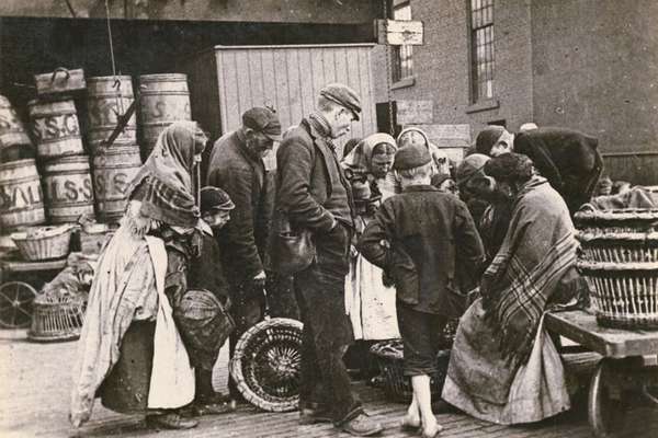 A group of people gather round a fish seller.