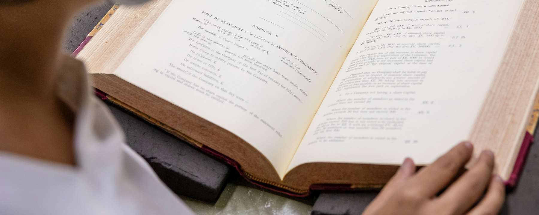 A person reads a large book.