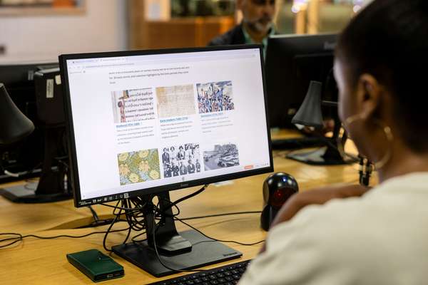 A visitor conducts research on a computer.