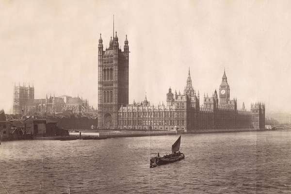 A Victorian photograph of the Houses of Parliament with the Thames in front. A small boat sails on the river.