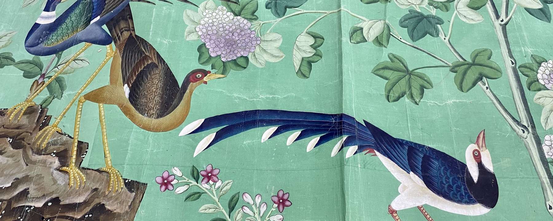 Colourful Chinese painted wallpaper with birds and flowers on a green ground