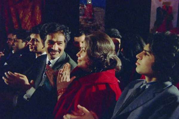 A still from Insaaf. A South-Asian family sit in a theatre watching the stage