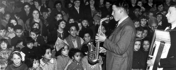 A saxophonist and accordion player entertain a rapt audience