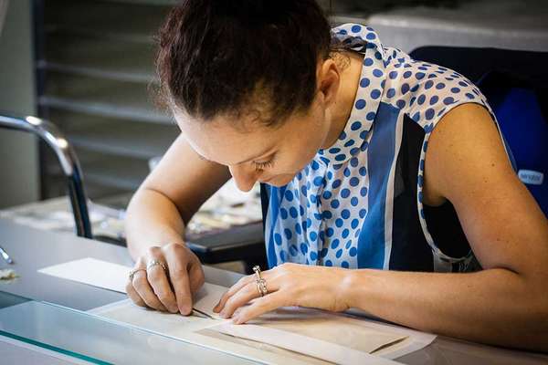 A conservator working closely on a document.