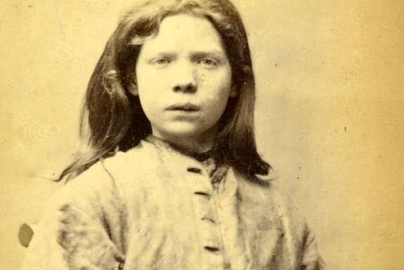 Mugshot of a young girl. She looks into the camera with a confused expression.