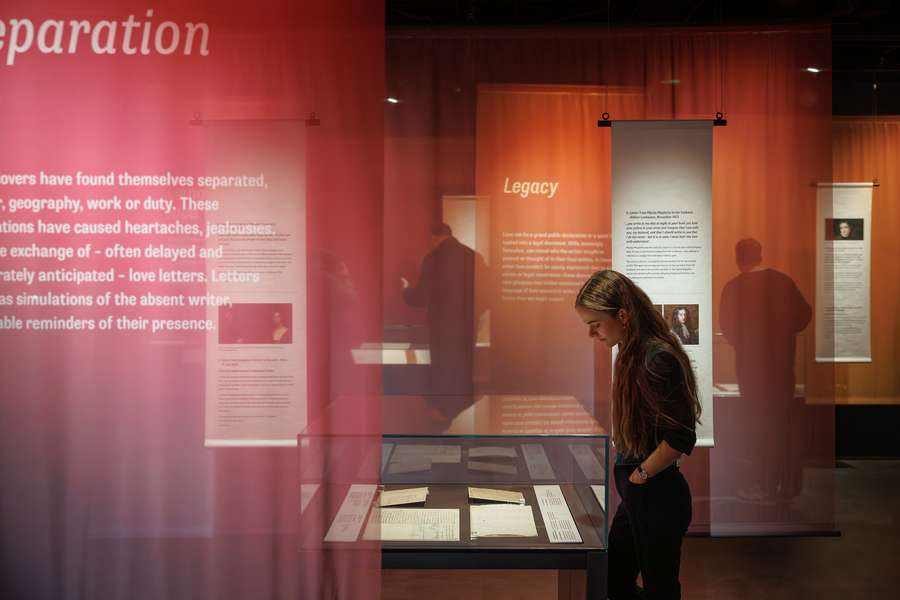A person looking at documents on display in an exhibition about Love Letters.