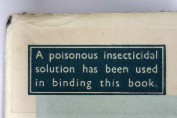 A label indicating an insecticide solution has been applied to the binding of a book.