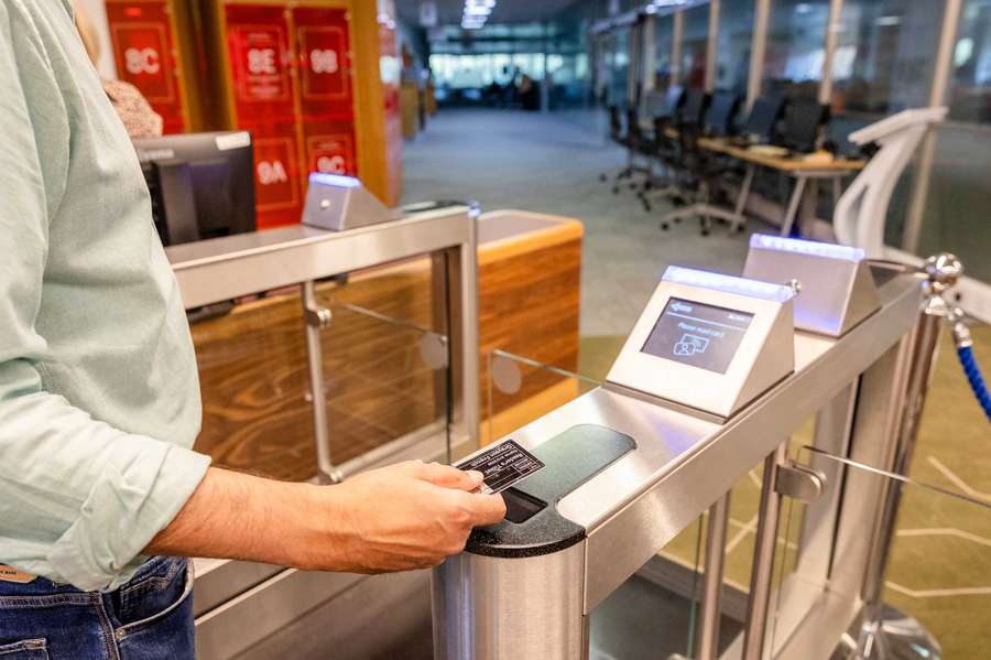 A visitor taps their reader's ticket - a plastic card the size of a credit card - on a security barrier.