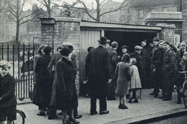 Newspaper clipping with a photo of people gathered outside the entrance.