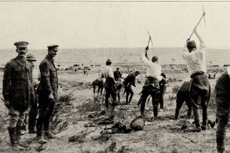 Photograph of First World War soldiers digging trenches in an arid landscape.