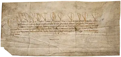 A wide yellowed sheet with five lines of Medieval Latin written in brown ink.