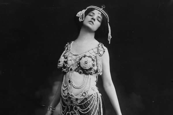 Allan dressed as Salome. She wears a beaded cropped top and translucent skirt