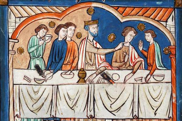 A group of men sit at a table. Edward the Confessor, clad in a crown, sits in the middle and points towards his left.