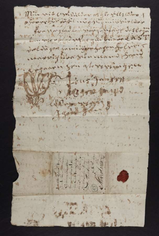 A single sheet of paper with fewer than ten lines of handwritten text, with lines overleaf showing through, and a small wax seal stuck to it.
