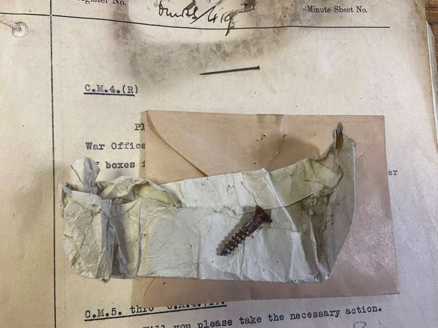 A screw sat on top of paper documents