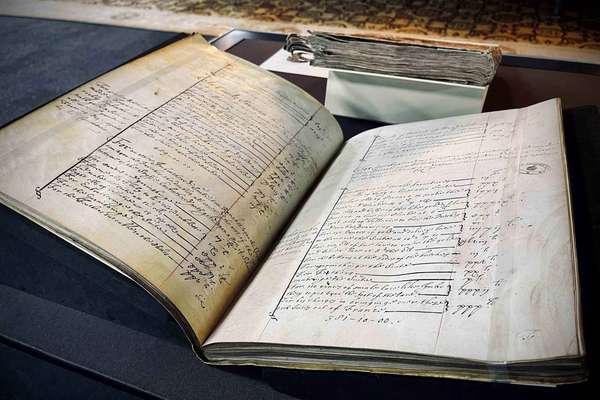An opened historical volume in a display case.