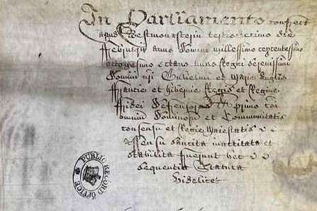 A browned piece of paper with hand written text