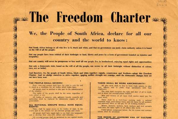 A poster on bright orange paper with a decorative border, filled with printed text setting out the Charter's demands.