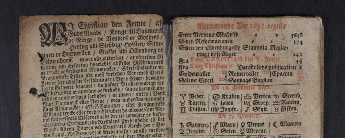 An opened volume showing two pages of ornately handwritten Danish text, including some astronomical symbols.