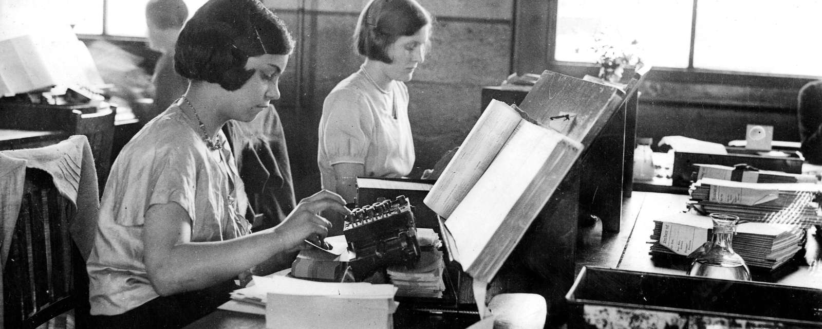 black and white photo of two women working at a desk with punch cards