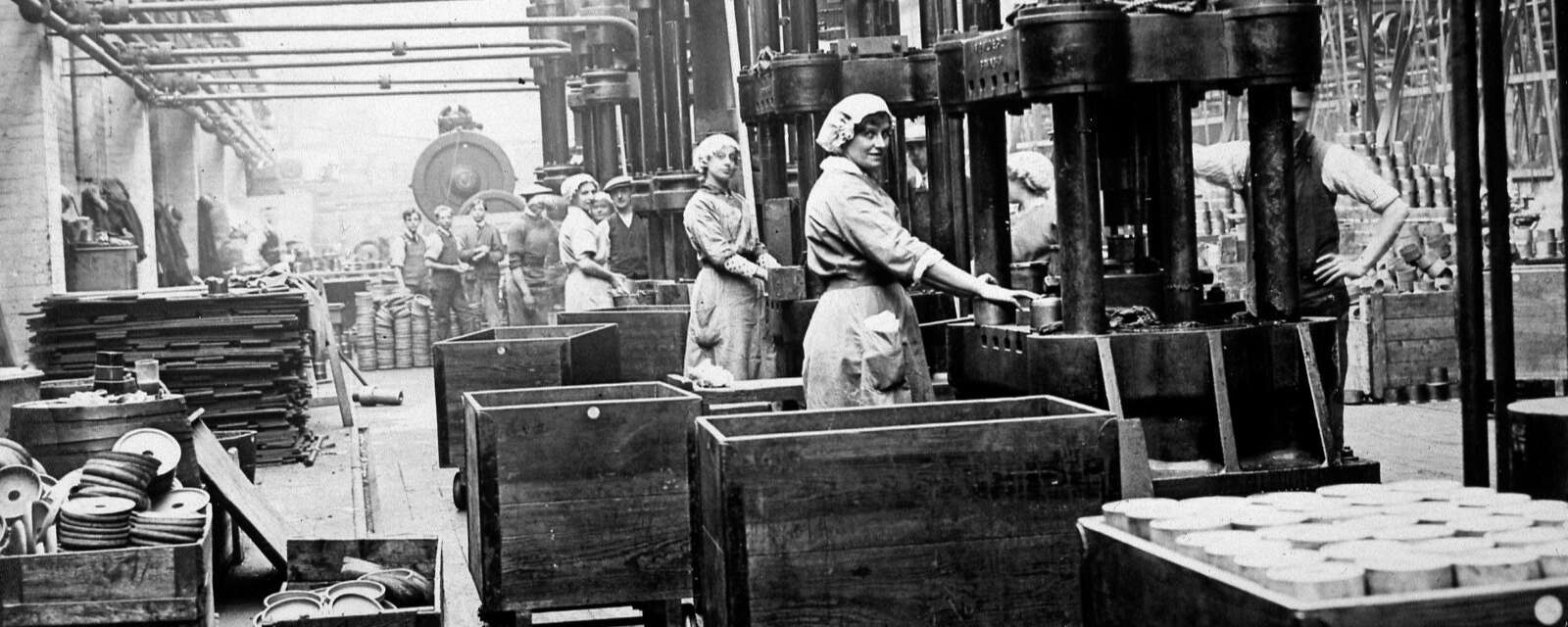 A black and white photo of women working in a munitions factory