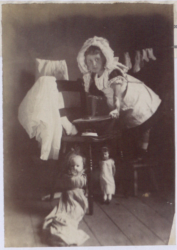 Girl playing with dolls, 1891. There is a caption underneath which reads reads "Now I am mother" (COPY 1/405 f.282)