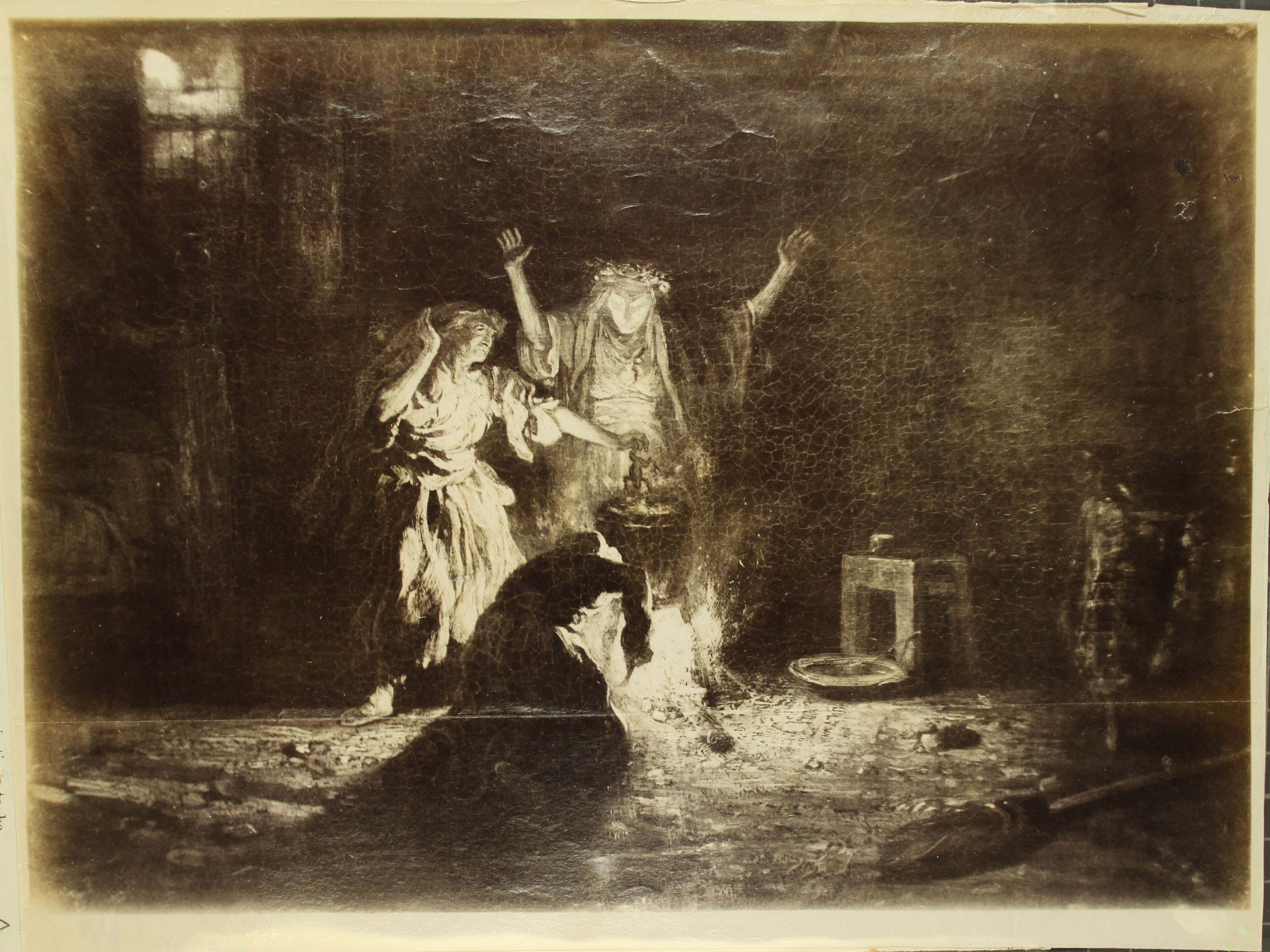 Three witches stand around a boiling pot. One stirs the pot, one stokes the fire, and one lifts her hands while looking into it.