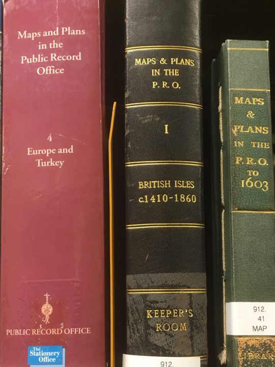 The spines of three hardback books - some of the published catalogues of maps and plans held at The National Archives (previously the Public Record Office).