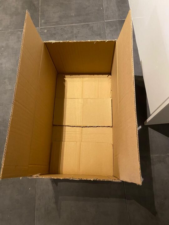 An empty cardboard box, opened at the top.