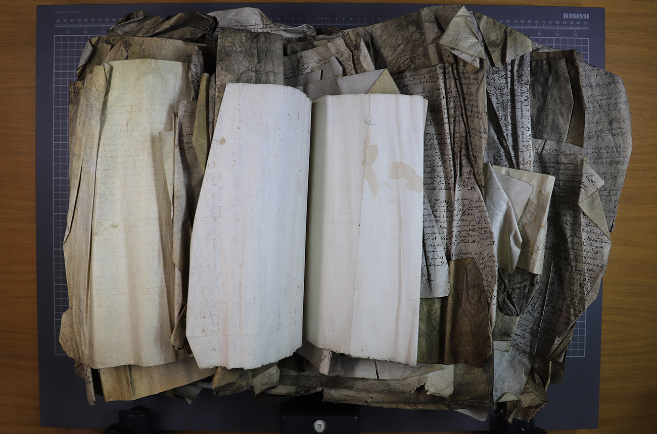 A large bundle of documents from the 1600s with dozens of pages folded together rather messily. Many of the pages are folded and creased.