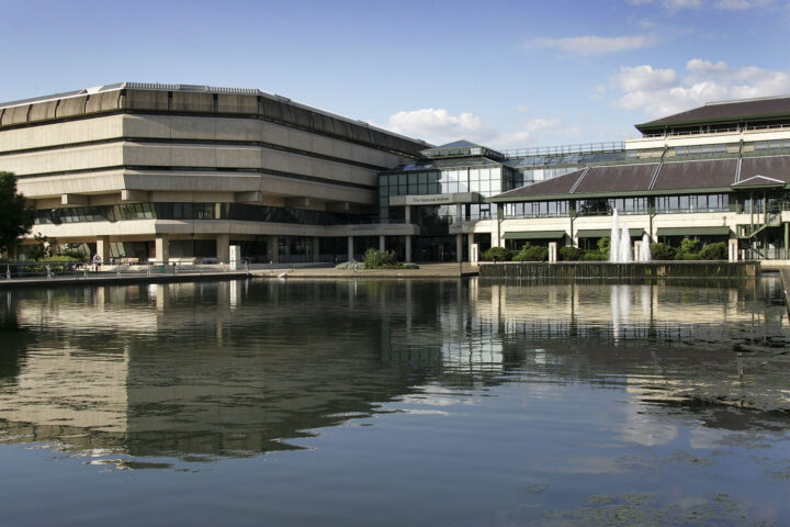 The National Archives building, a large multi-storey concrete building with very small windows on the top three floors connected to a more modern glass building.