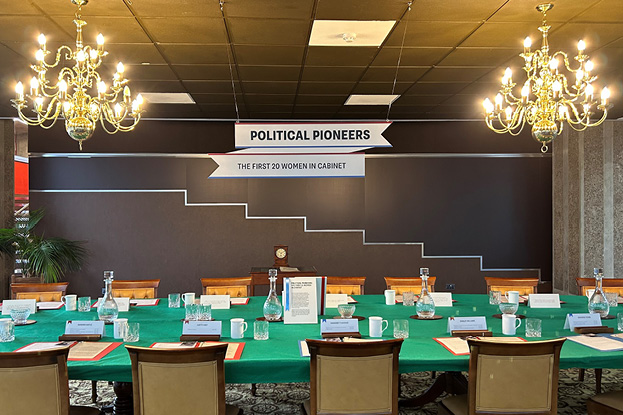 Image of the cabinet table Political Pioneers display, showing hanging sign, table, chairs and facsimile documents laid out