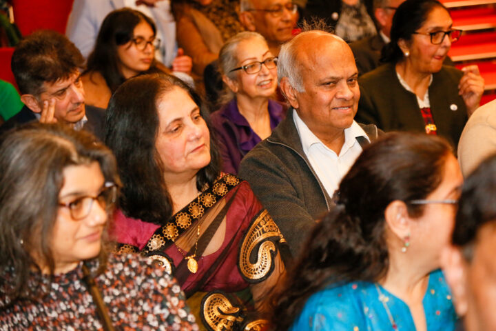 Close-up of South Asian audience members sitting in an auditorium.