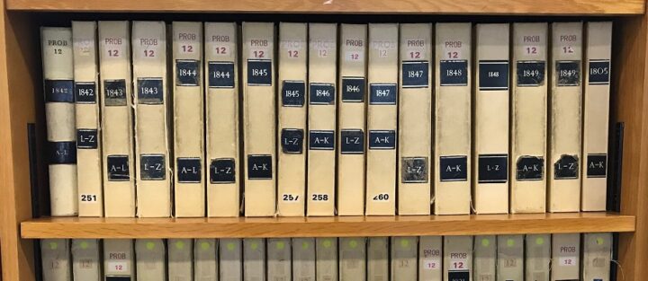 Bound volumes of PROB 12 indexes on the shelves in the Open Reading Rooms at The National Archives in Kew. These are copies of the original indexes, used by the court, to administration act books and to wills.