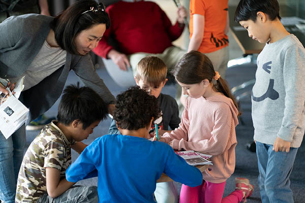 Children gathered around a family craft activity at a Time Travel Club event at The National Archives