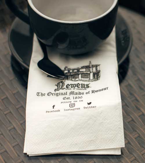 A coffee cup sat on a Maids of Honour napkin.
