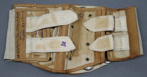 A Victorian cream and white belt, folded together. It has two white straps.