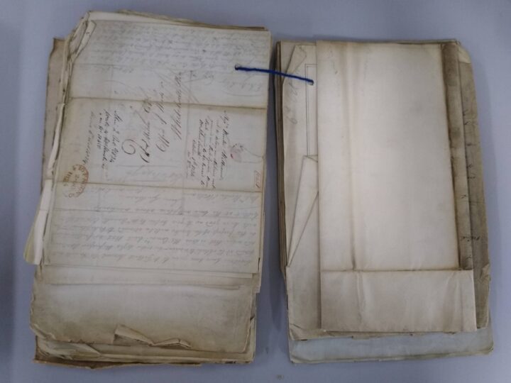 An open tagged file lying flat on the table, containing a large, folded map. 