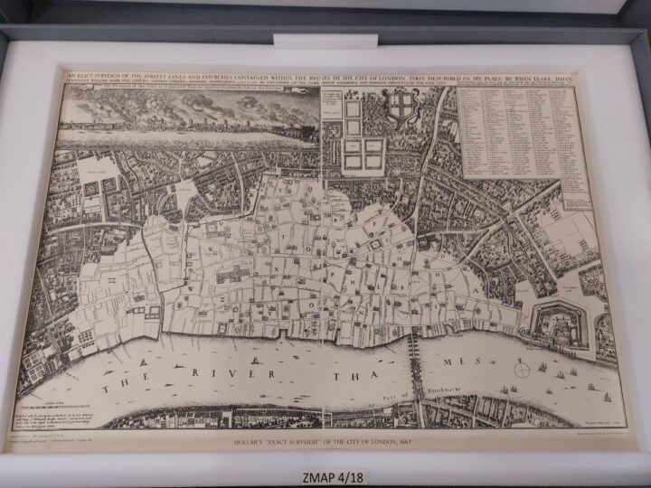 A large paper map of London, surrounded by white foam boarders and in a grey case. 