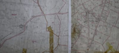 Brown-coloured pressure sensitive tape covers old tears on large maps.