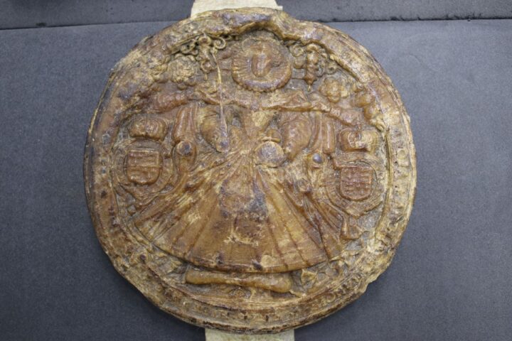 A large brown wax seal depicting Queen Elizabeth I in the centre. 