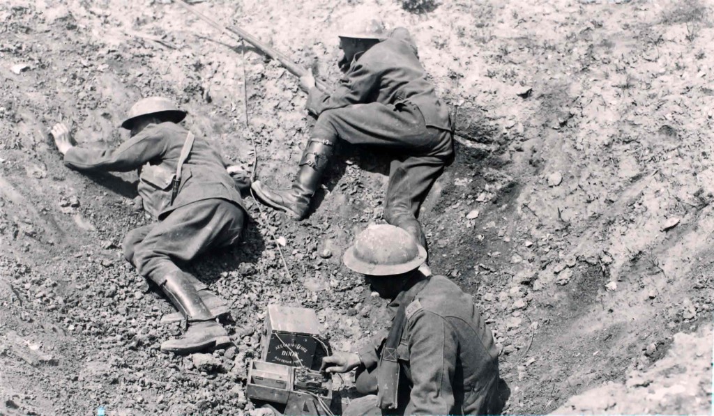 Soldiers in trench hole using a morse code machine (BT Archives cat ref: TCB 417 E36705)