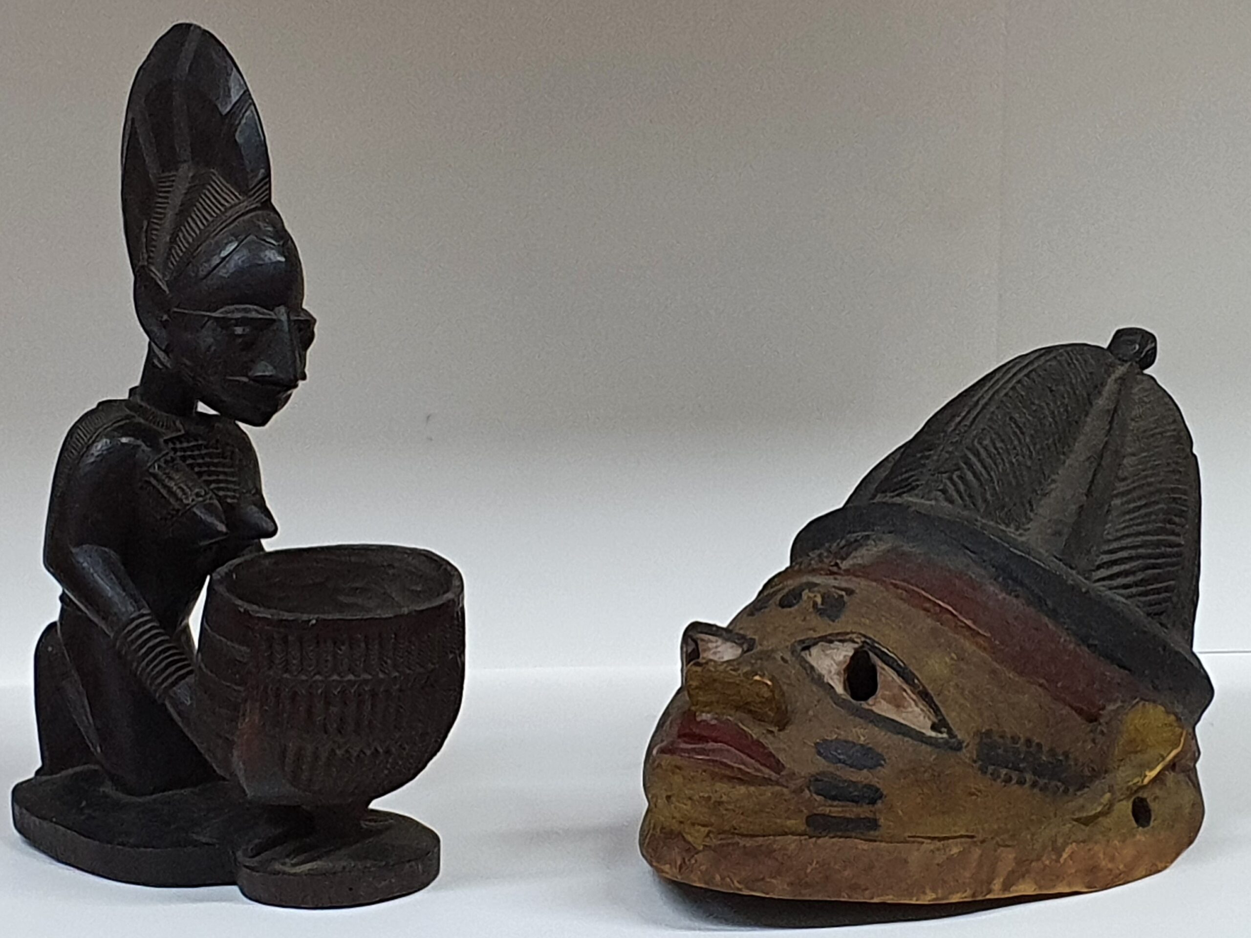 A small wooden statue and a wooden mask