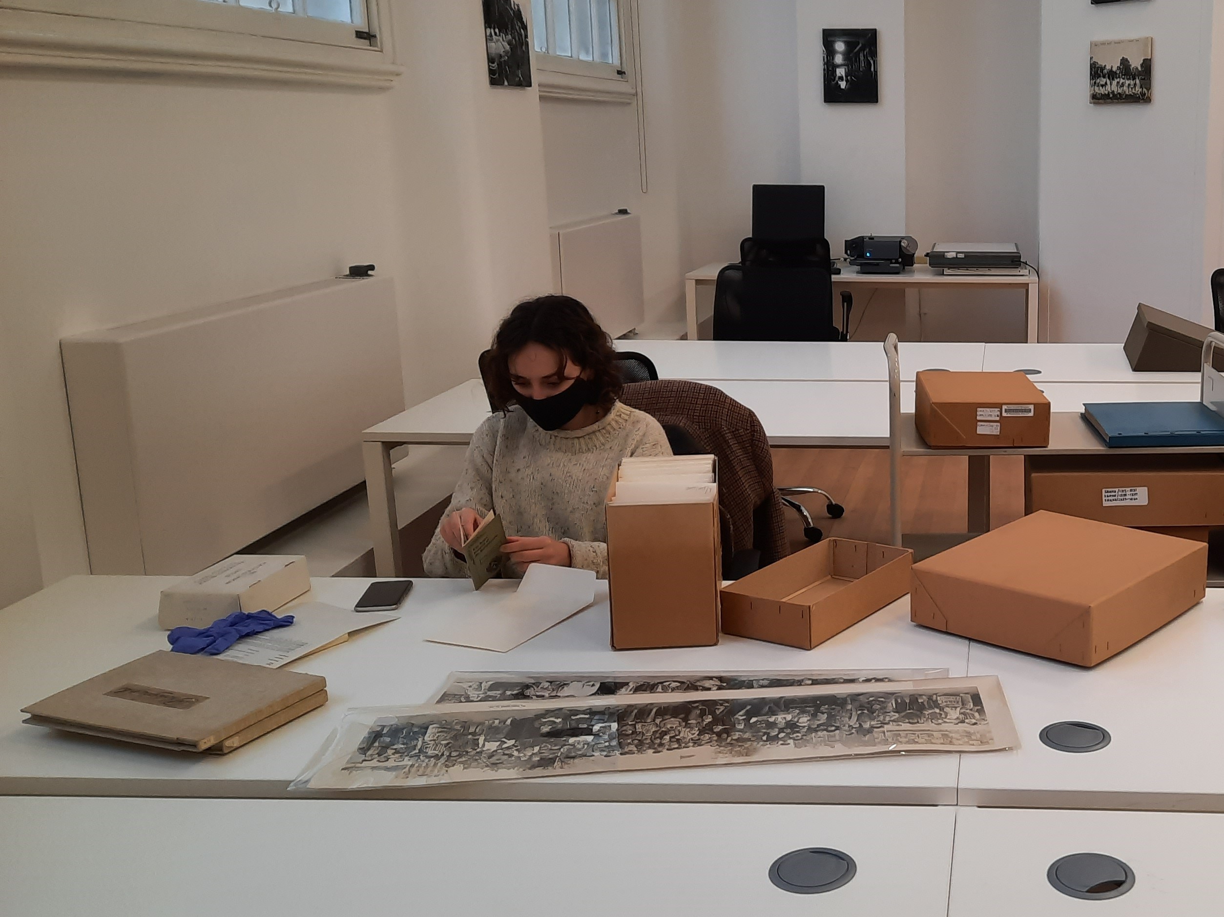 A person looking at long photographs on a table in a reading room