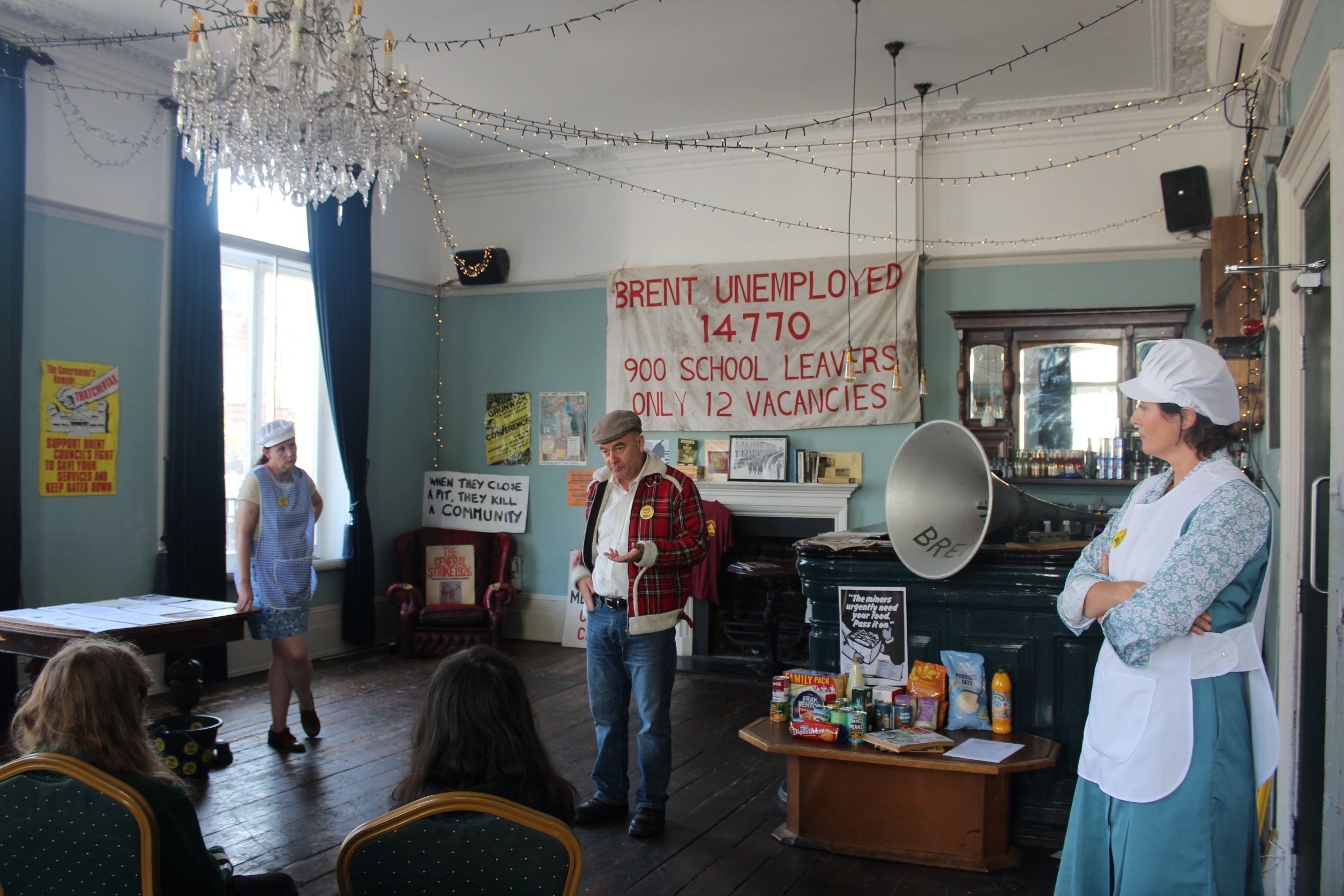 Three people performing in the immersive theatre experience 'Coal, Dole and Dinner Ladies'