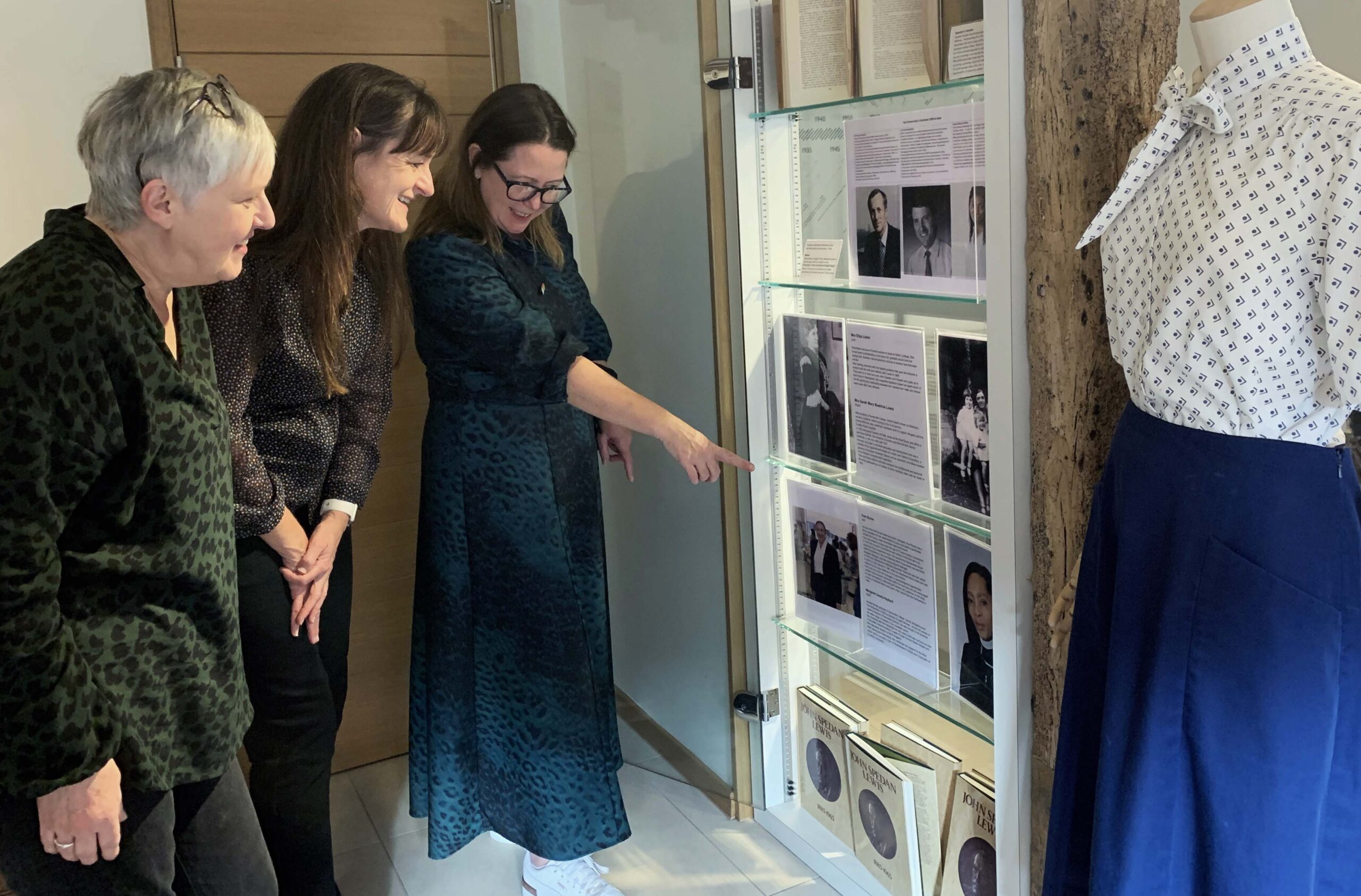 Three woman looking at a display of photographs
